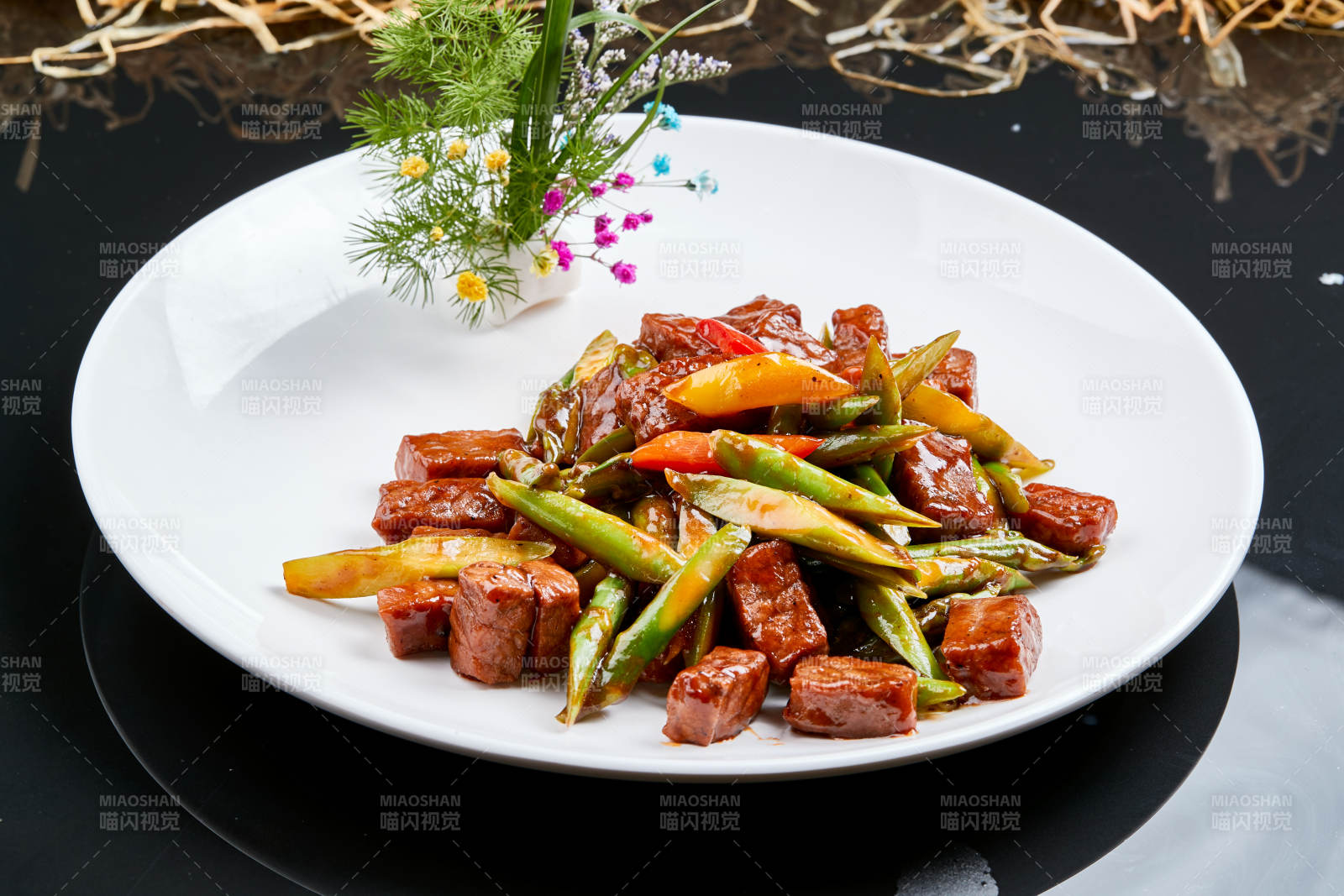 白色瓷盘装的黑胡椒鲜芦笋小炒牛仔粒图片