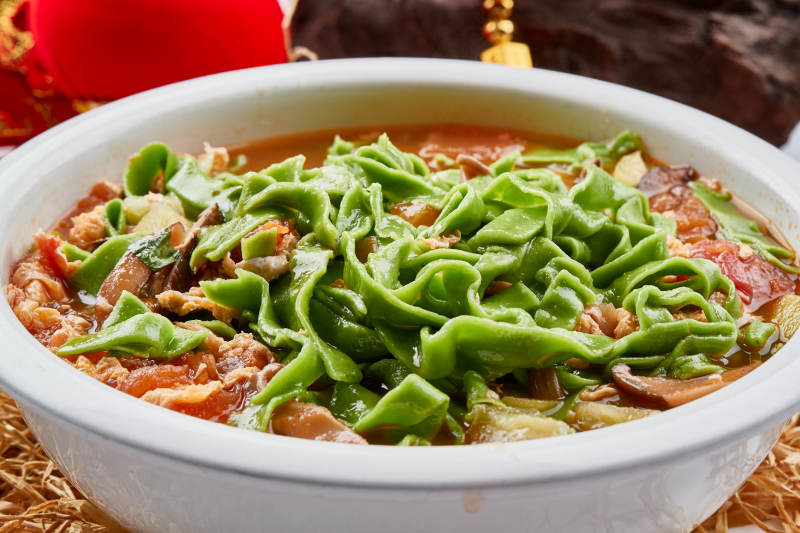 精美瓷餐具装的腊肉菠菜面图片