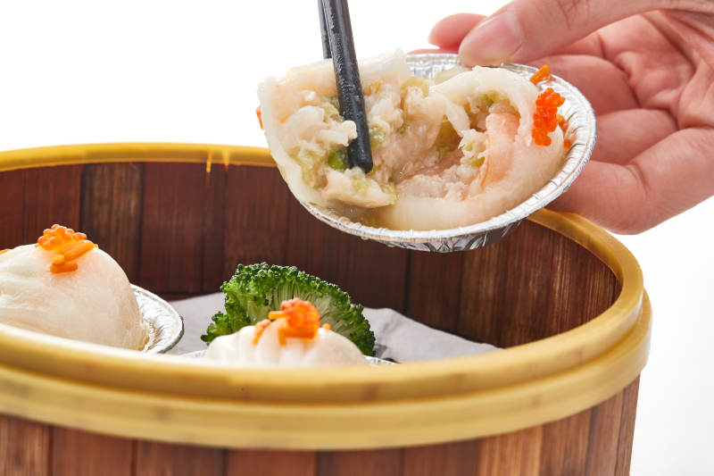 白色背景下精美竹笼屉装的港式茶餐蒸虾饺图片