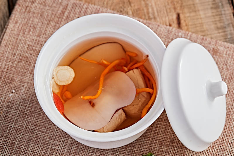 白色瓷汤盅装的木薯党参虫草花炖老鸭汤图片