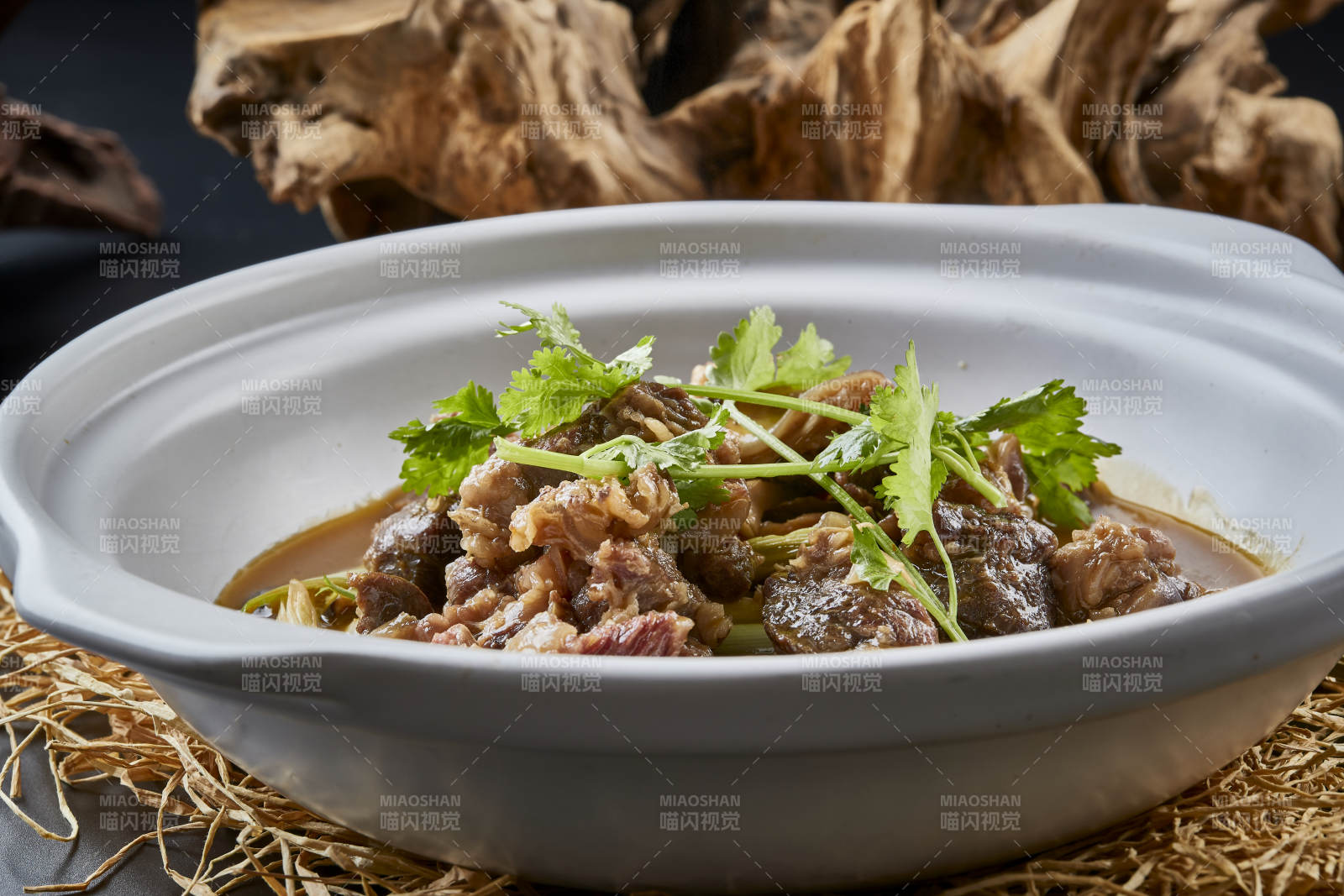 白色砂锅装的蒜苗浓汤炖牛腩图片