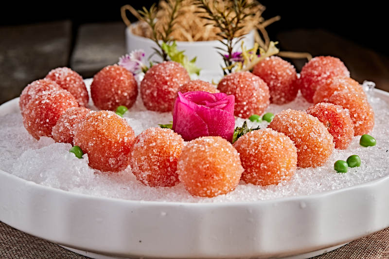 布满碎冰的餐具装的QQ糖衣冰冻圣女果图片