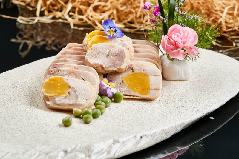 精美餐具装的鸡胸肉压咸蛋黄切片图片