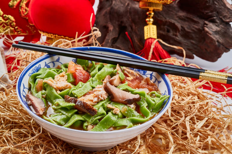 精美瓷餐具装的腊肉菠菜面图片