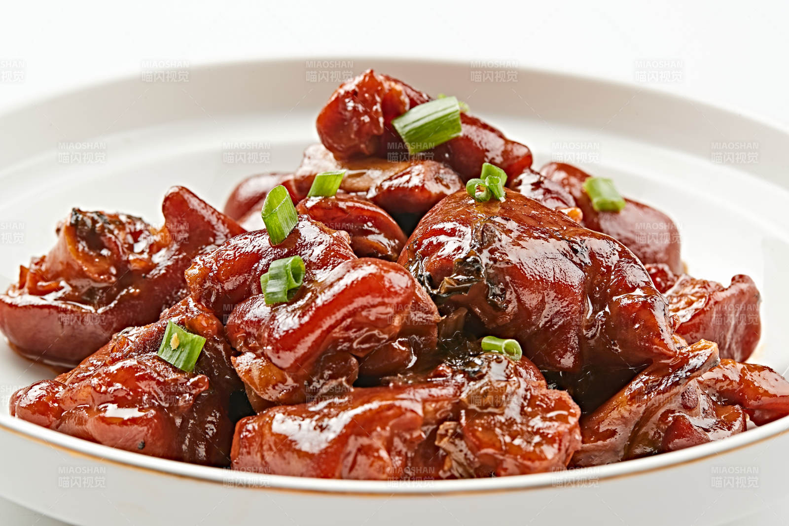 白色瓷盘装的酱香红烧猪蹄块图片