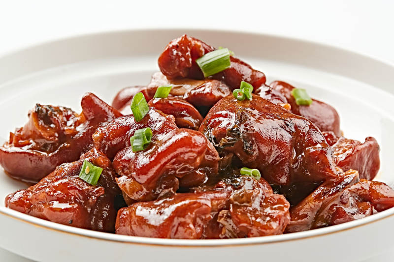 白色瓷盘装的酱香红烧猪蹄块图片