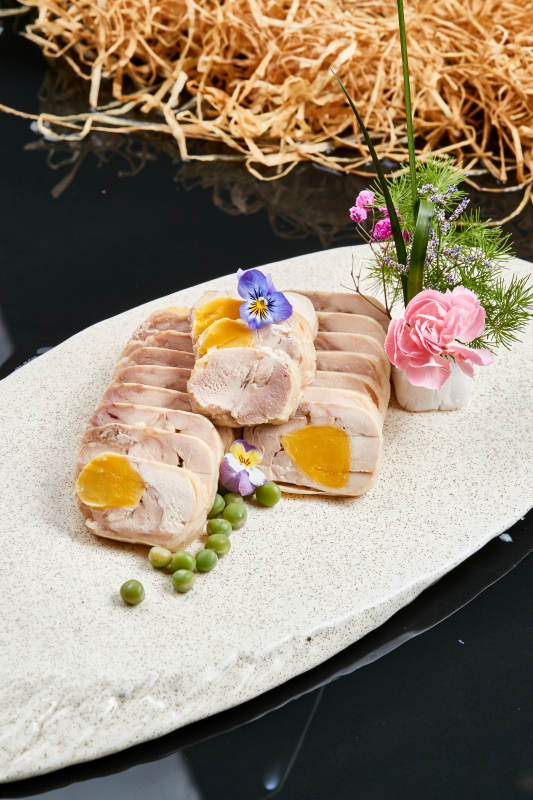 精美餐具装的鸡胸肉压咸蛋黄切片图片