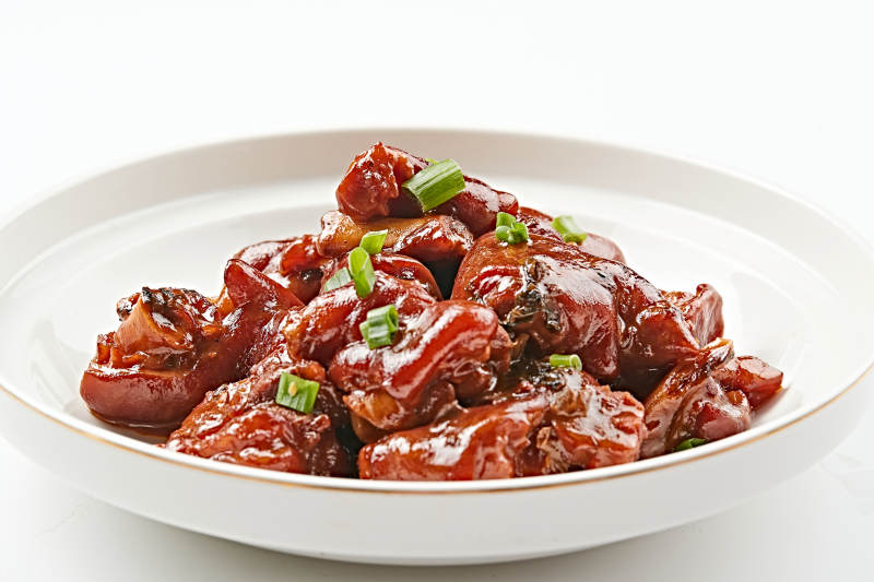 白色瓷盘装的酱香红烧猪蹄块图片