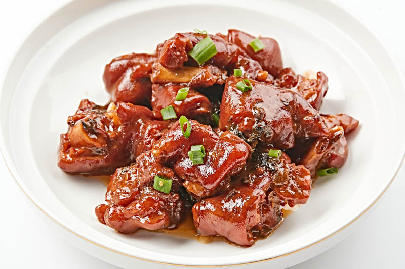 白色瓷盘装的酱香红烧猪蹄块图片