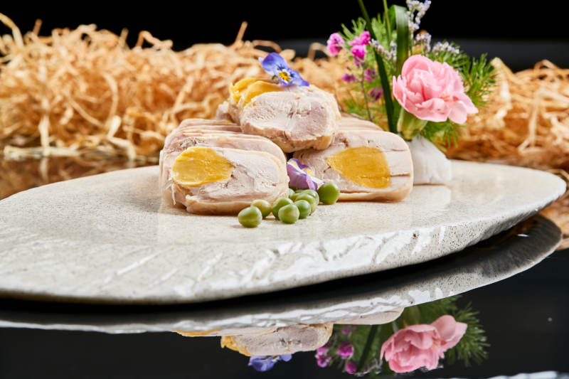 精美餐具装的鸡胸肉压咸蛋黄切片图片