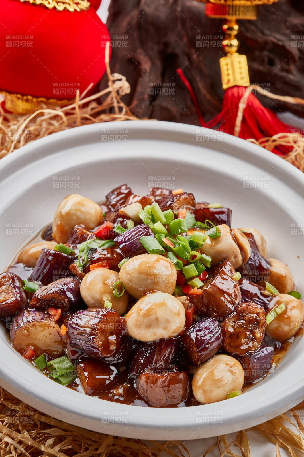 白色砂锅装的香辣鹌鹑蛋茄子煲图片