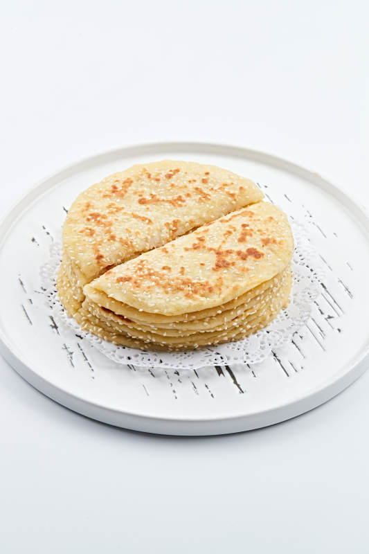 白色瓷盘装的现烙葱油酥饼图片