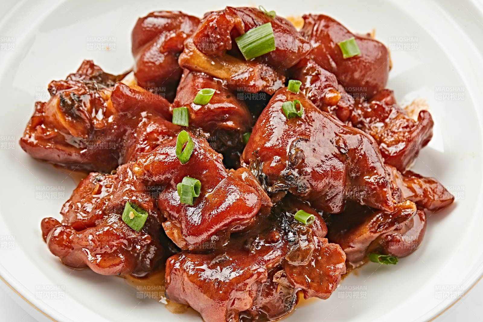 白色瓷盘装的酱香红烧猪蹄块图片