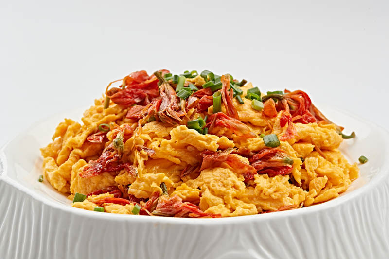 白色瓷盘装的赤百合炒鸡蛋图片