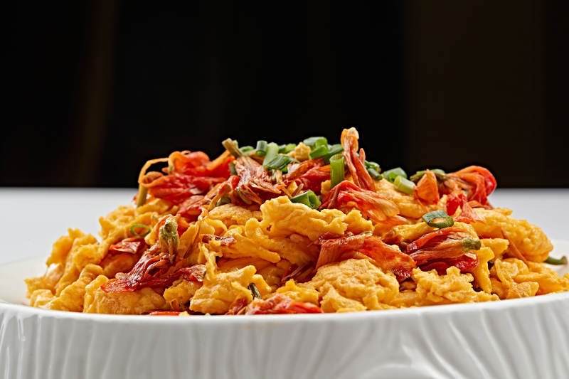 白色瓷盘装的赤百合炒鸡蛋图片