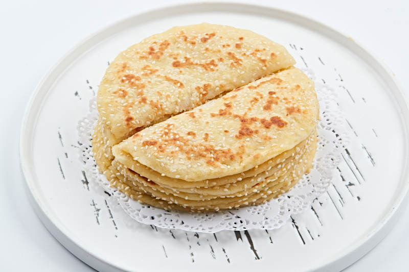 白色瓷盘装的现烙葱油酥饼图片