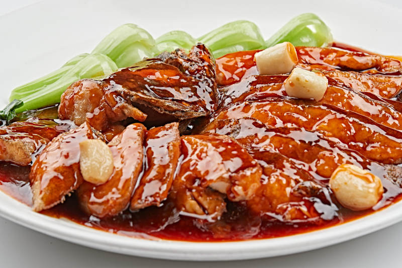 白色瓷盘装的照烧鲽鱼尾图片