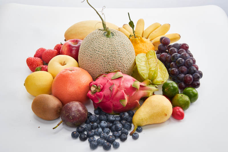 白色背景上摆放的生鲜混合水果图片