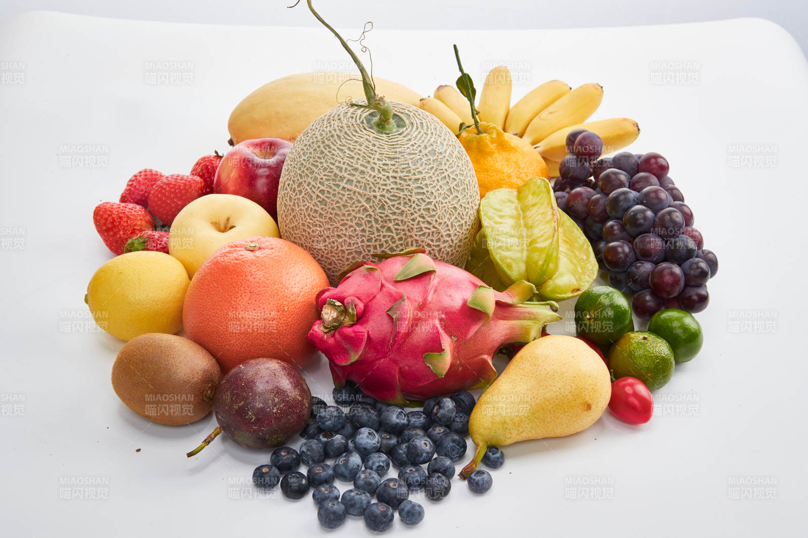 白色背景上摆放的生鲜混合水果图片