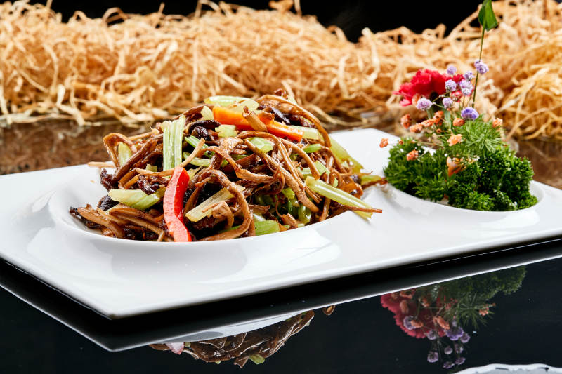 白色瓷盘装的双椒丝木耳小炒茶树菇图片