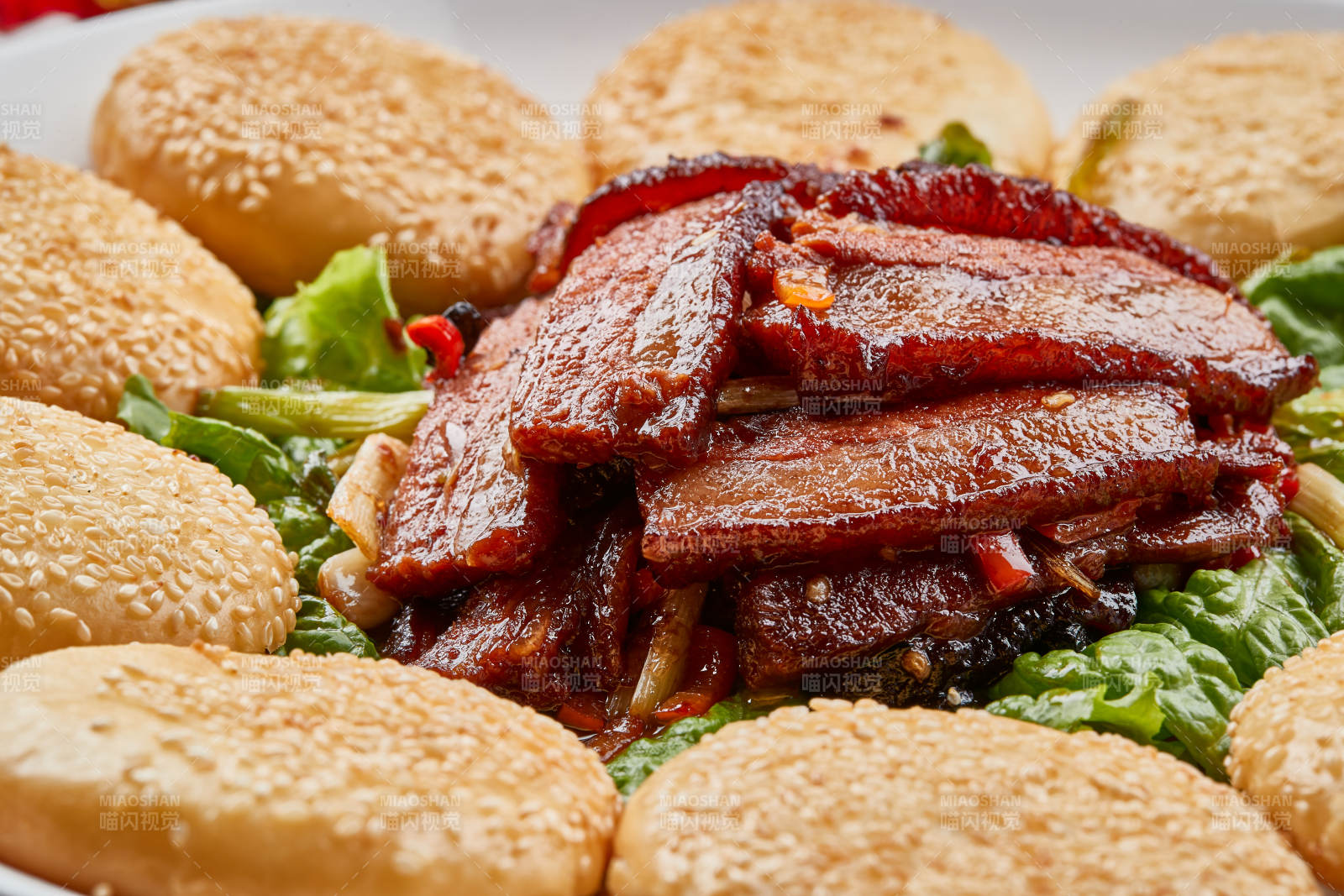 白色瓷盘装的芝麻锅盔肉夹馍图片