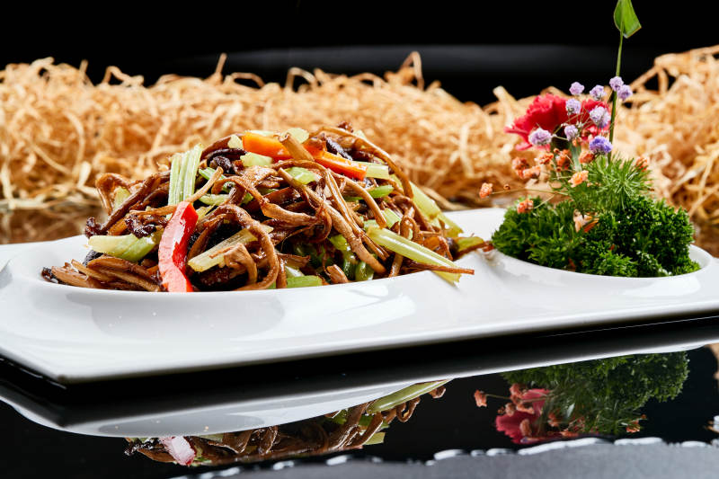 白色瓷盘装的双椒丝木耳小炒茶树菇图片