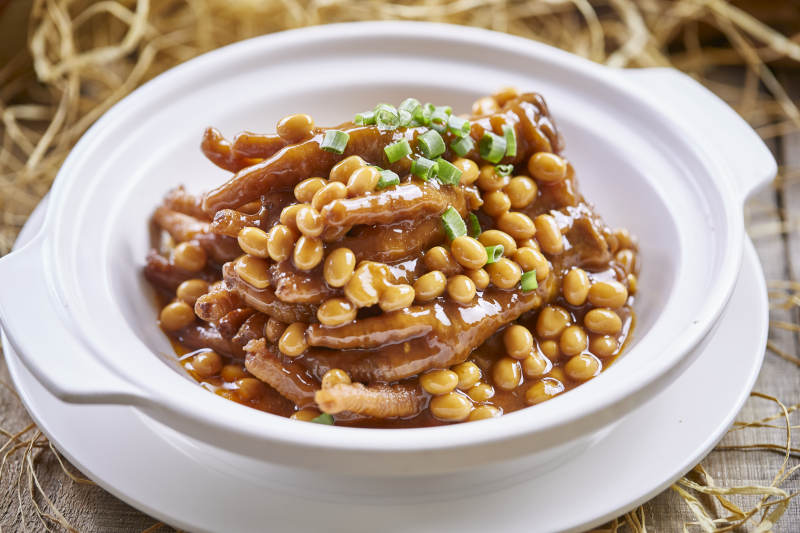 白色砂锅装的黄豆焖鸡脚凤爪图片