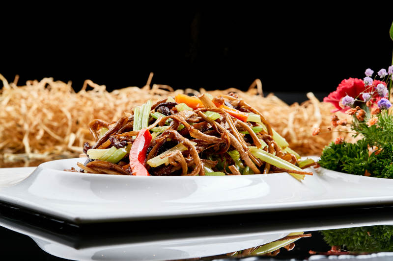 白色瓷盘装的双椒丝木耳小炒茶树菇图片