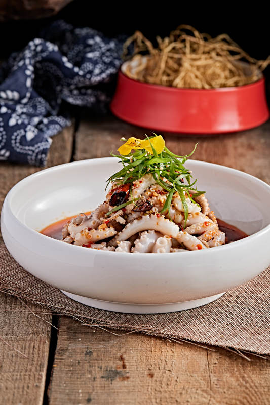 白色瓷盘装的红油醋腌章鱼爪图片