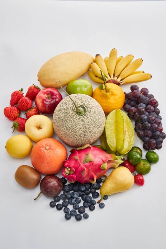 白色背景上摆放的生鲜混合水果图片