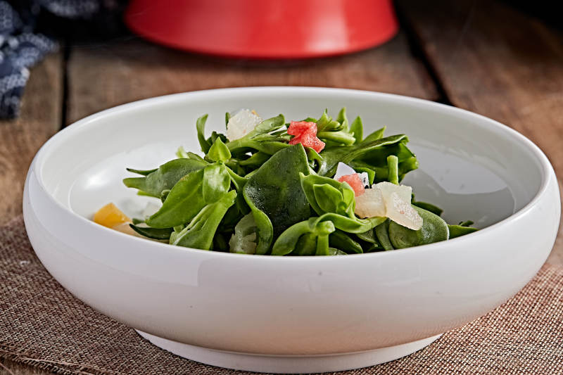 白色瓷盘装的的水果粒炝拌穿心莲图片