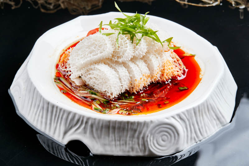 白色瓷盘装的川味红油魔芋肚图片