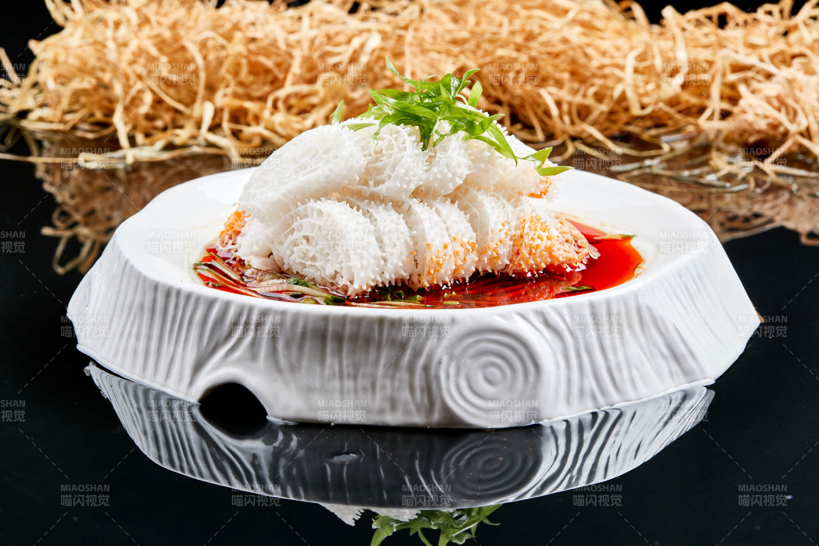 白色瓷盘装的川味红油魔芋肚图片