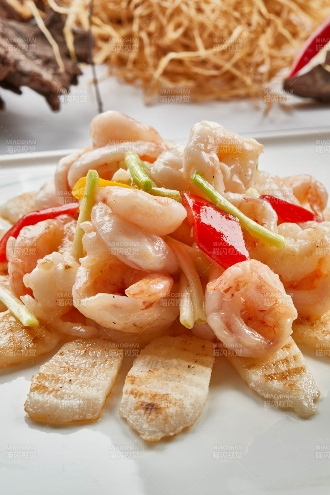 白色瓷盘装的铁板杏鲍菇清炒大虾仁图片