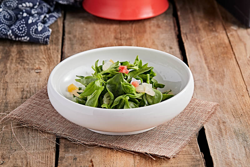 白色瓷盘装的的水果粒炝拌穿心莲图片