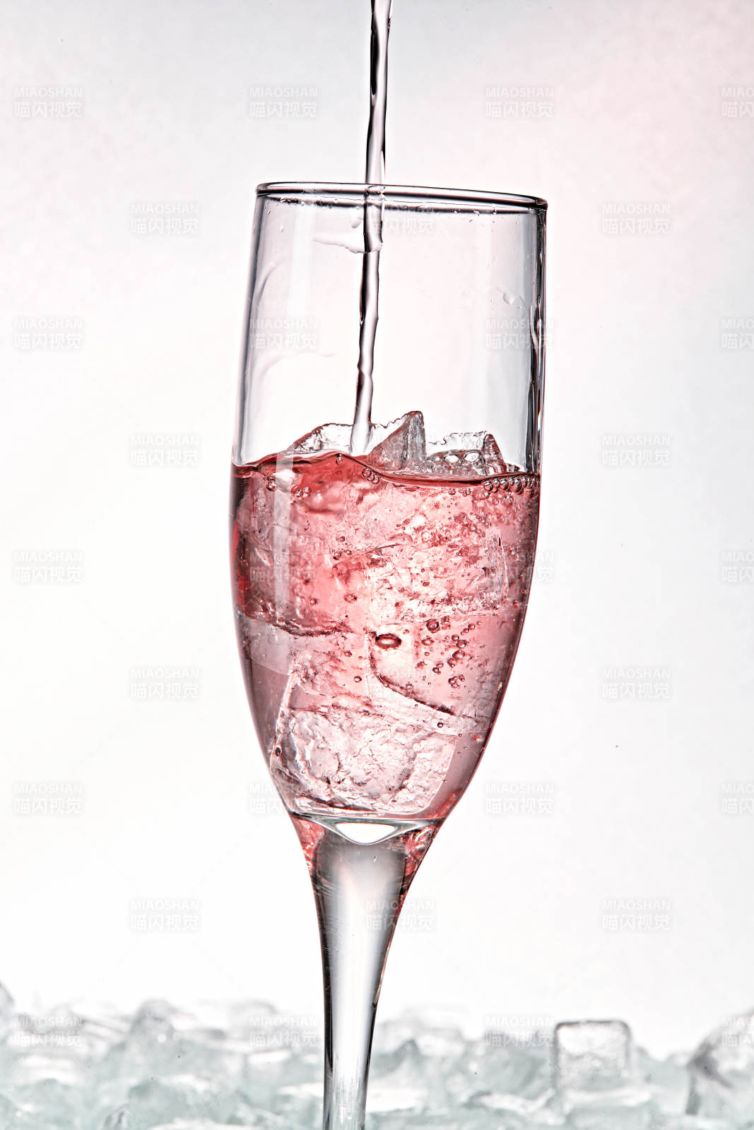 布满冰块的酒杯中的清凉桃子味预调酒图片