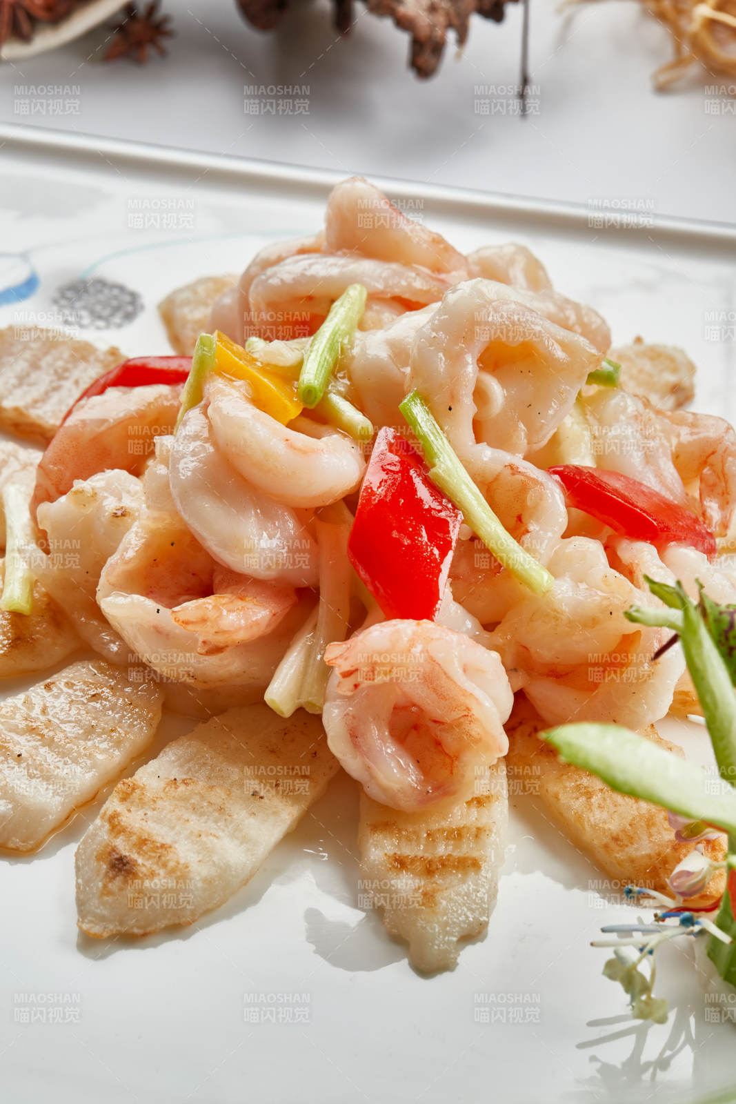 白色瓷盘装的铁板杏鲍菇清炒大虾仁图片