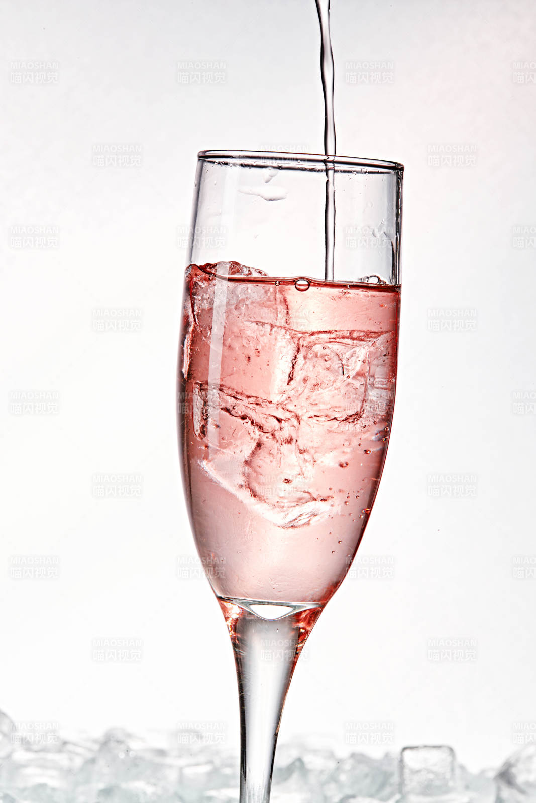 布满冰块的酒杯中的清凉桃子味预调酒图片