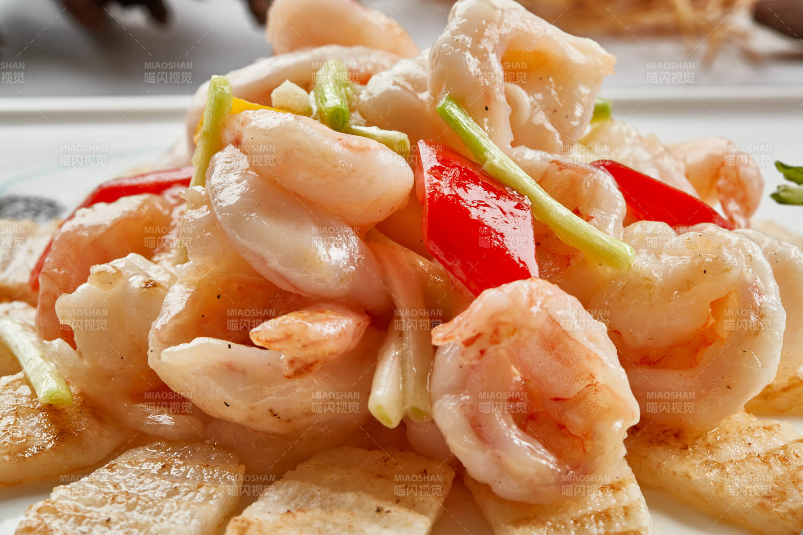 白色瓷盘装的铁板杏鲍菇清炒大虾仁图片