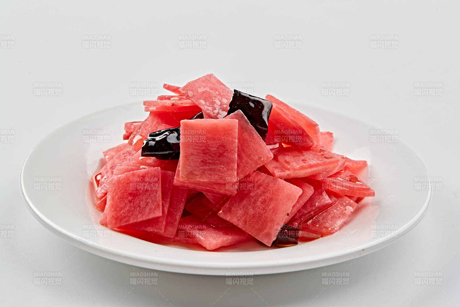 白色瓷盘装的红醋香辣萝卜皮图片