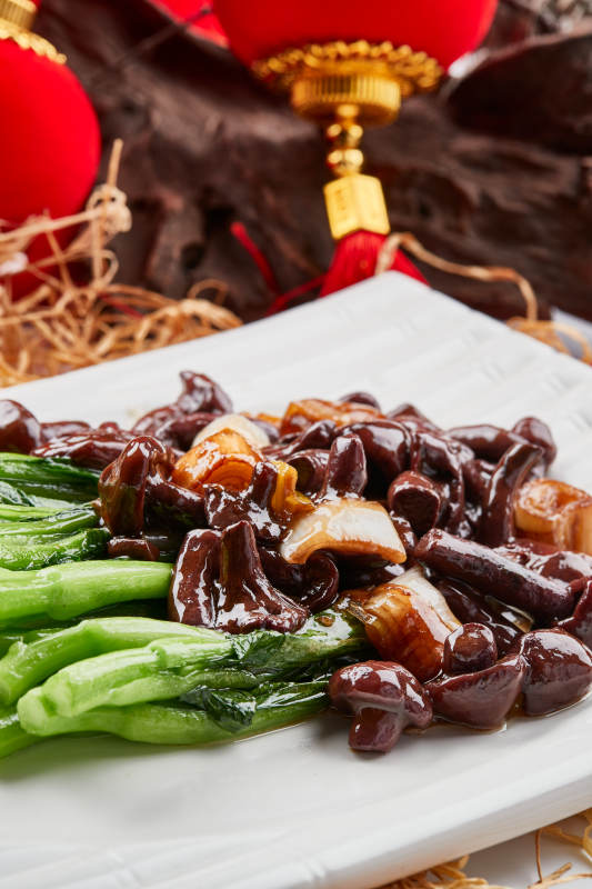 白色瓷盘装的芥蓝白灼红肉菇图片