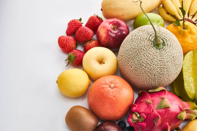 白色背景上摆放的生鲜混合水果图片