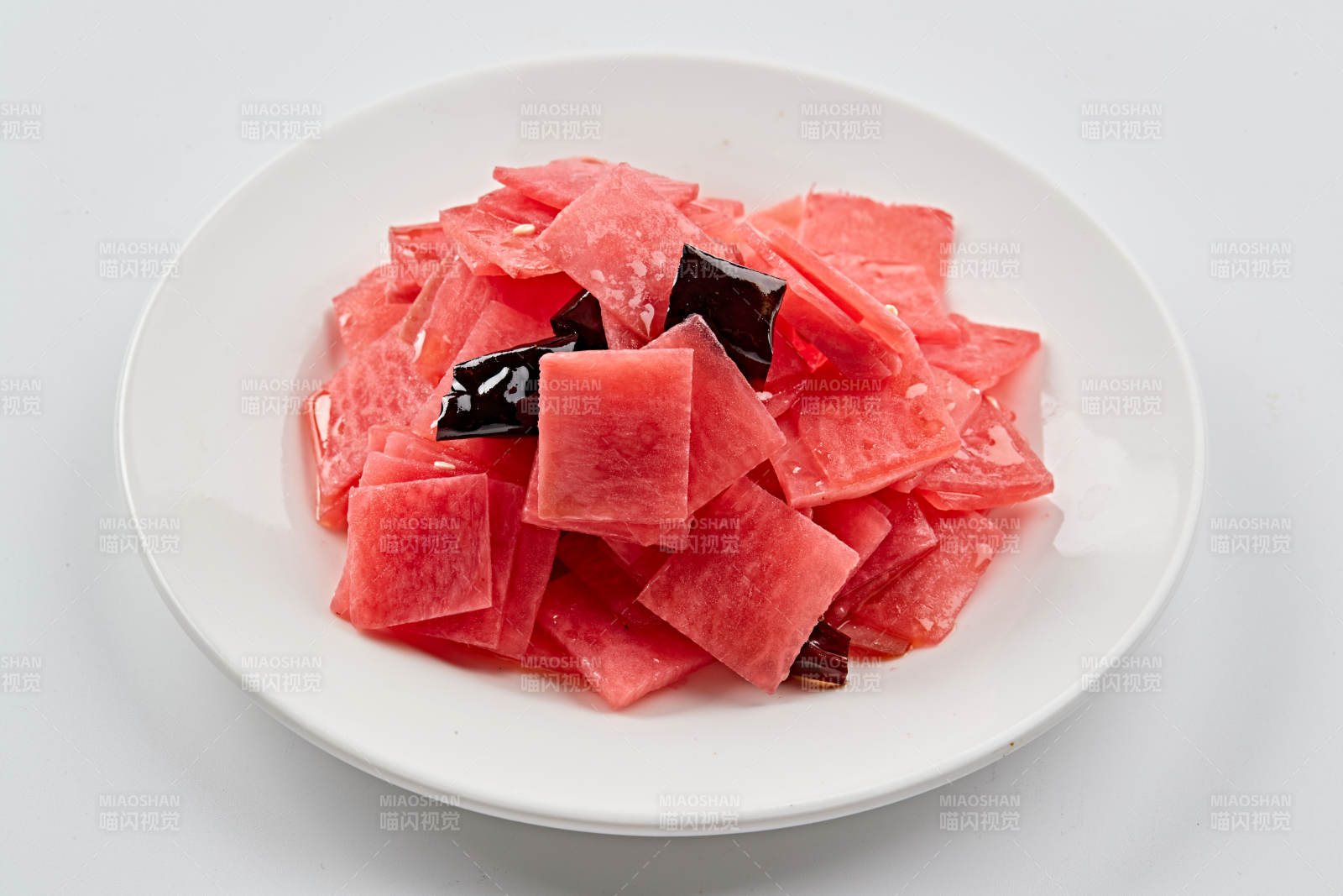 白色瓷盘装的红醋香辣萝卜皮图片