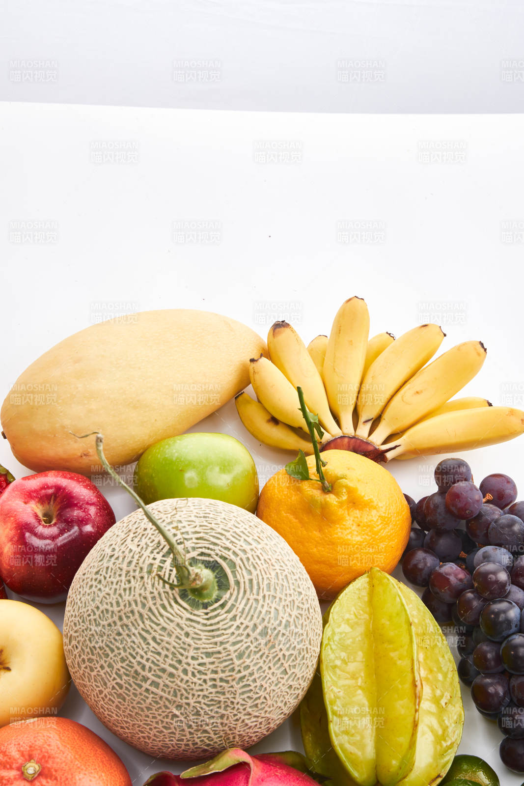 白色背景上摆放的生鲜混合水果图片