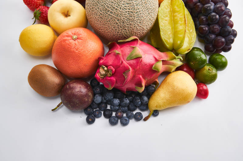 白色背景上摆放的生鲜混合水果图片