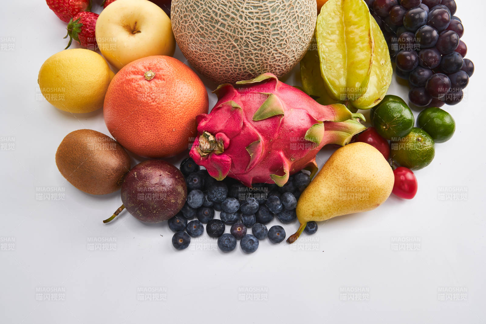 白色背景上摆放的生鲜混合水果图片