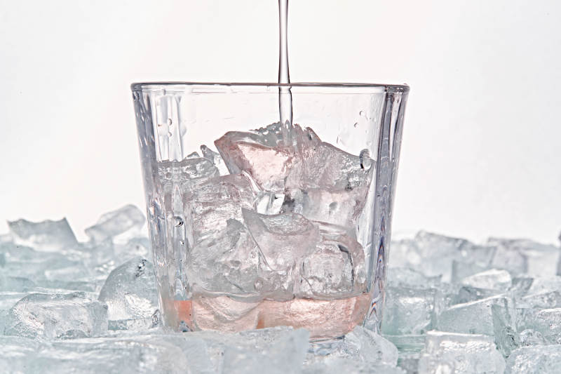 布满冰块的酒杯中的清凉桃子味预调酒图片