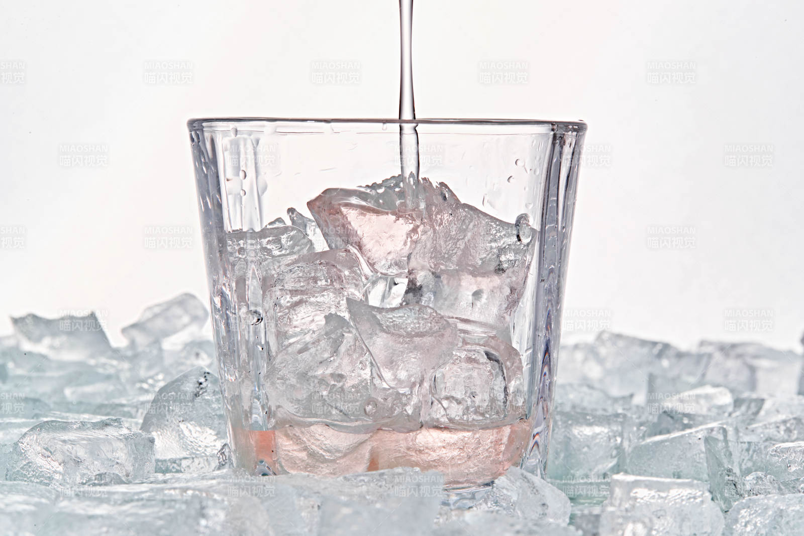 布满冰块的酒杯中的清凉桃子味预调酒图片