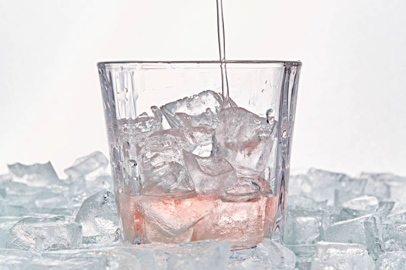 布满冰块的酒杯中的清凉桃子味预调酒图片