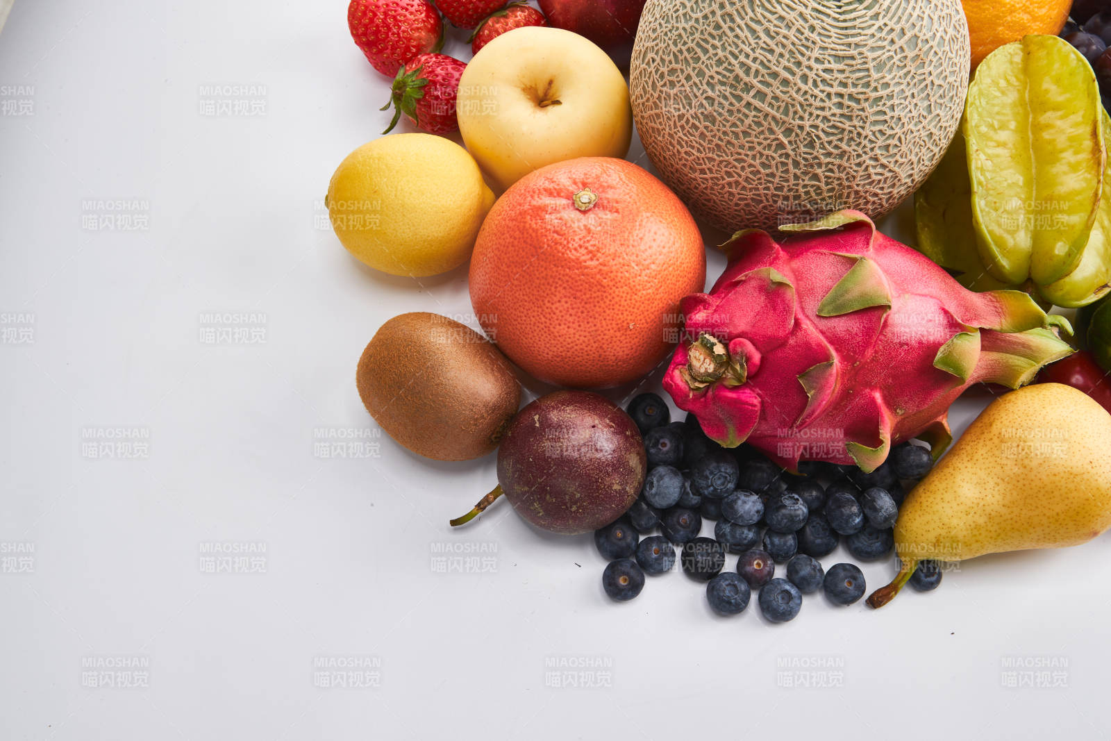 白色背景上摆放的生鲜混合水果图片